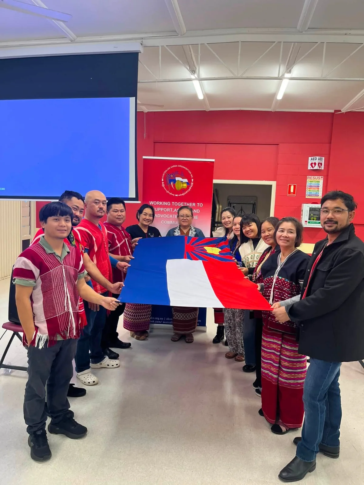 AKO Queensland’s new leaders standing together holding the Karen flag.